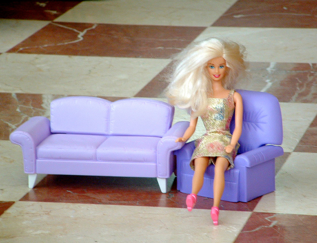 panenka Barbie sedící na modré pohovce